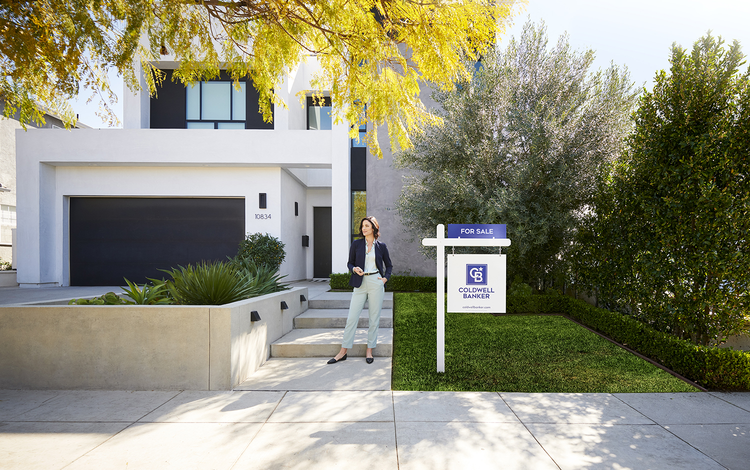 Agent standing in front of a house with a Coldwell Banker signage